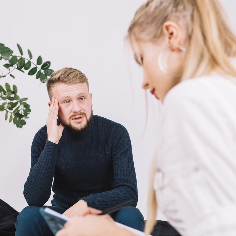 portrait depressed male patient talking with female psychologist